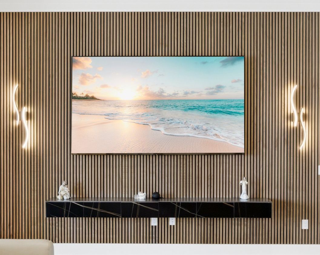 Living room wall clad floor to ceiling in natural wood slats, with a wall-mounted TV, two sculptural light sconces and a floating black console